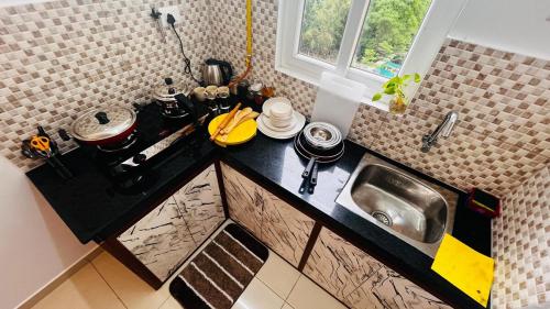 a small kitchen with a sink and a counter at Aesthetic Studio near Chettinadu Hospital in Kelambākkam