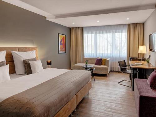 a hotel room with a large bed and a couch at Hotel Central in Hof
