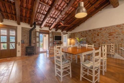 a kitchen and dining room with a wooden table and chairs at Casa En Vistes Al Montsià I Prop in Ulldecona