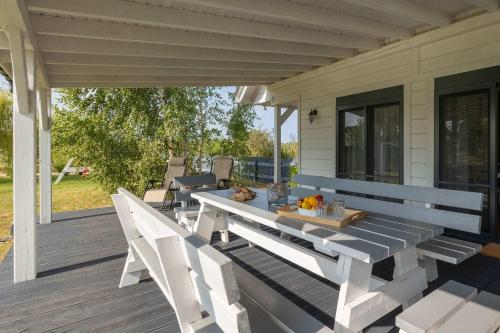 a table and chairs sitting on a porch at Baltic Home Houses Zastań with Parking by Noclegi Renters in Zastań