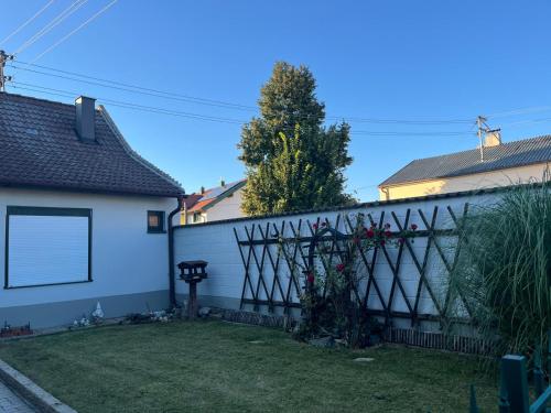 a fence in front of a house with a yard at FeWo Ehmann in Frauenkirchen