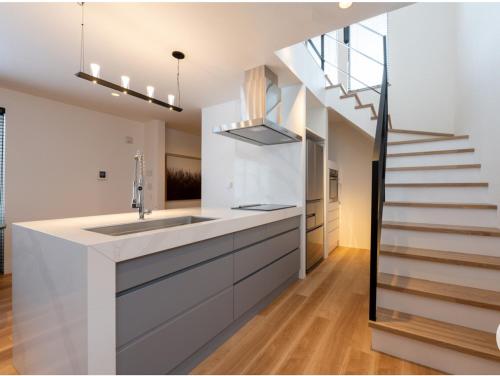 a kitchen with a sink and a staircase at Forest Avenue 64 in Niseko