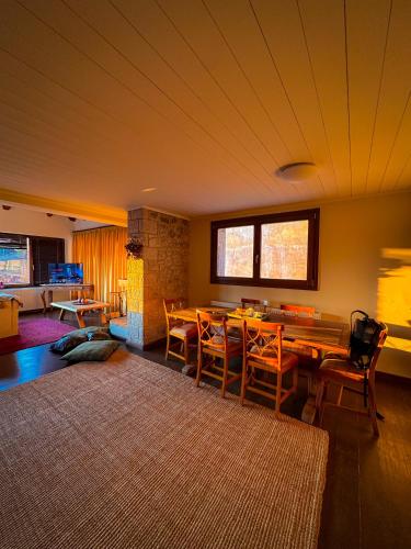 a living room with a wooden table and chairs at Veranda Villa in Arachova