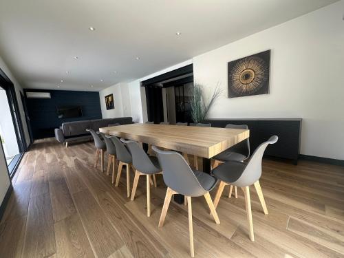 a dining room with a wooden table and chairs at La Villa Estienne - Spacieuse - Conviviale - 6 Chambres - Parking privé in Mont-de-Marsan