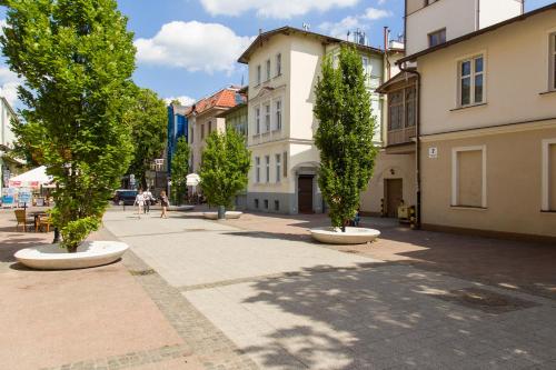 a street with trees and buildings in a city at Sopot Point in Sopot