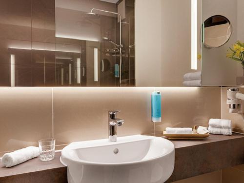 a bathroom with a white sink and a mirror at Hotel Central in Hof