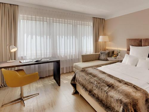 a hotel room with a bed and a desk at Hotel Central in Hof