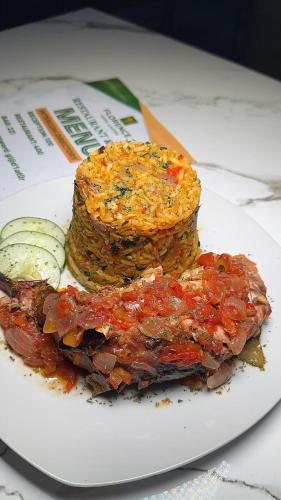 a plate of food with meat and vegetables on a table at Florence Hotel and suites in Benin City