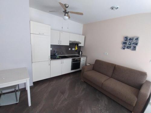 Una sala de estar con un sofá y una cocina. en New design NT, en Košice