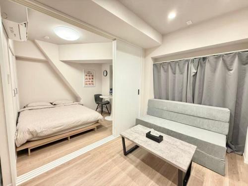 ein kleines Schlafzimmer mit einem Bett und einem Tisch in der Unterkunft Shinjuku 歌舞伎町E3 in Tokio