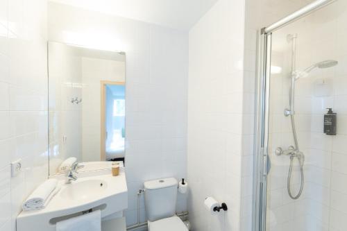 a bathroom with a toilet and a sink and a shower at ibis budget Le Mans Centre in Le Mans