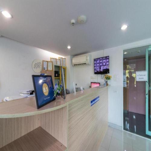 a waiting room with a counter with a tv on the wall at Collection O Siam Privi Hotel in Bangkok