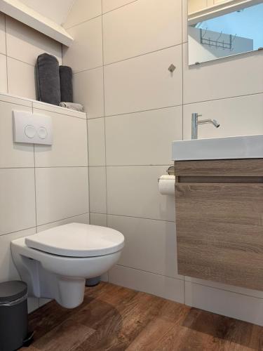 a white bathroom with a toilet and a sink at Eetcafé Punt in Roelofarendsveen
