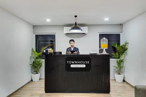 a man is standing behind a counter in a room at Super Townhouse T Nagar Chennai in Chennai