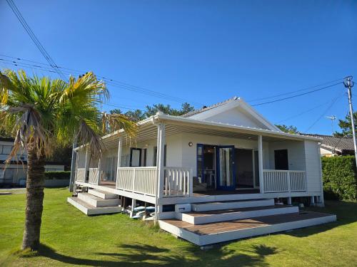a house with a palm tree in front of it at The Beach House ザ ビーチハウス