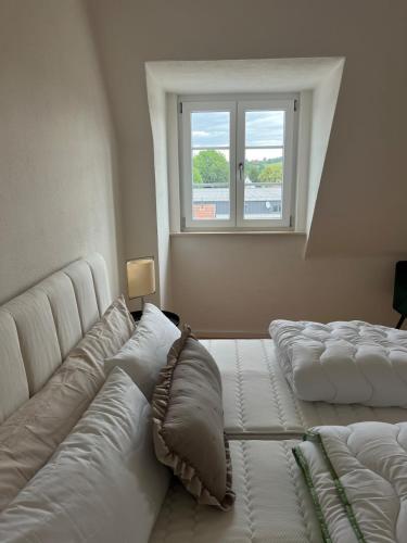 two beds in a room with a window at Elegantes Apartment in Villa in Ottobeuren