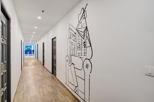 a hallway with a drawing on the wall at Super Townhouse T Nagar Chennai in Chennai