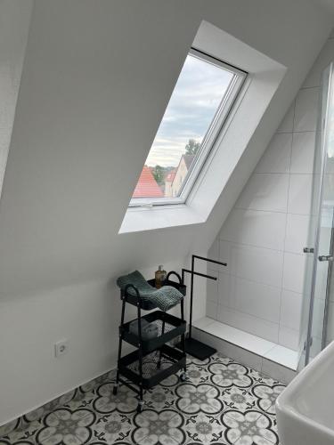 a bathroom with a skylight and a toilet and a chair at Elegantes Apartment in Villa in Ottobeuren