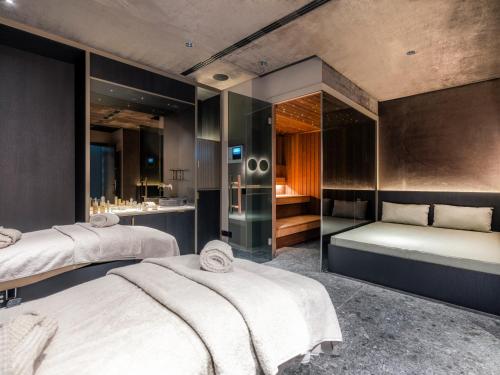 a bedroom with two beds and a bathroom at Steigenberger Icon Europäischer Hof Baden Baden in Baden-Baden