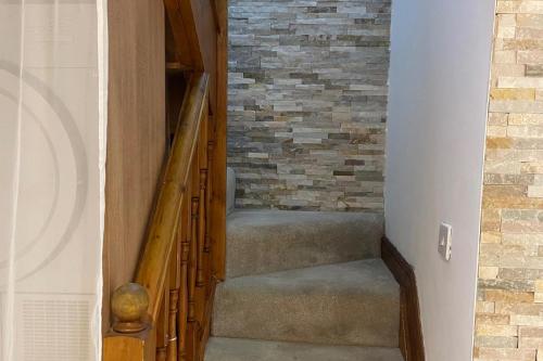 a staircase in a house with a brick wall at 4-Bed Barnwell Retreat- Sleeps 9 Garden & Parking in Stevenage