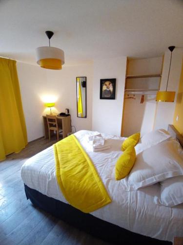 a bedroom with a large white bed with yellow pillows at Les Remparts in Montreuil-sur-Mer