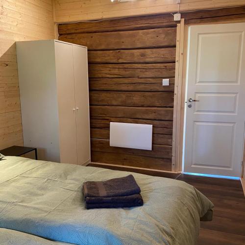a bedroom with a bed and a wooden wall at Villa Ragunda in Hammarstrand