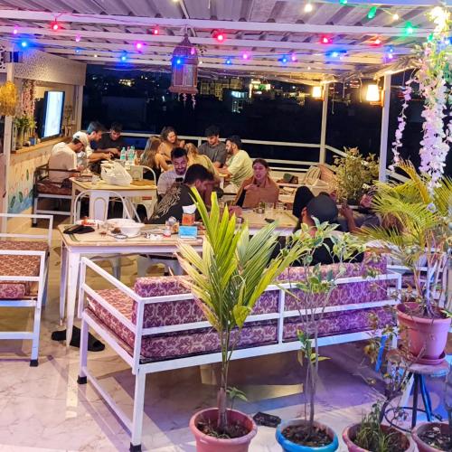 a group of people sitting at tables in a restaurant at Rising Shemesh Home Stay in Udaipur