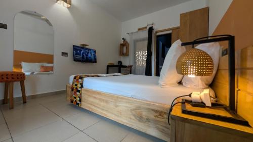 a bedroom with a bed and a lamp in it at La Maison de Canelya in Cotonou