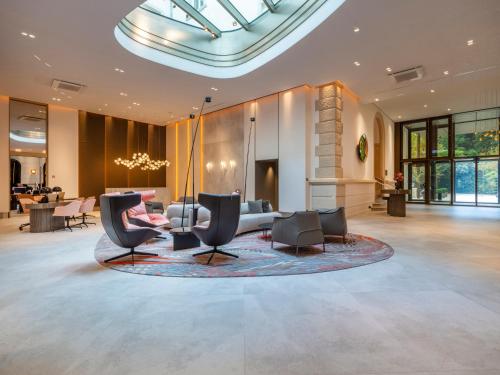 a lobby with chairs and a table in a building at Steigenberger Icon Europäischer Hof Baden Baden in Baden-Baden