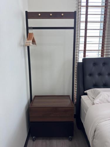 a bedroom with a bed and a wooden nightstand at Blue Moon House in Tawau