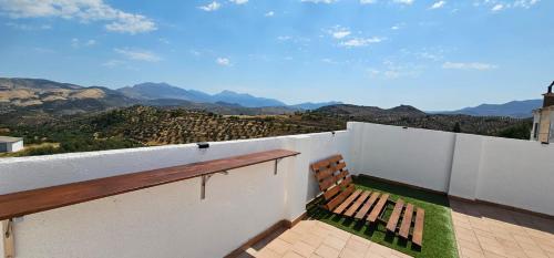 a bench sitting on a wall with a view of mountains at Casa rural Aires de Magina Jaén in Carchel