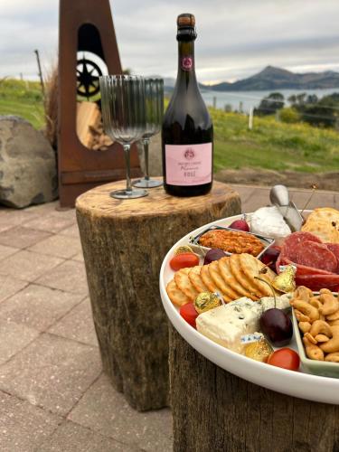 a plate of food and a bottle of wine at Harbour Hideaway in Dunedin