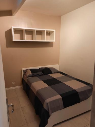 a bedroom with a bed with a black and white blanket at Le Cocon in Meudon