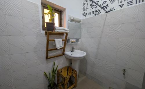 a bathroom with a sink and a toilet in a room at La Maison de Canelya in Cotonou