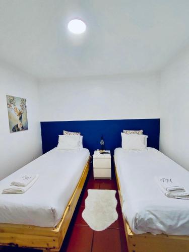 two beds in a room with blue and white walls at Brincalquimia in Setúbal
