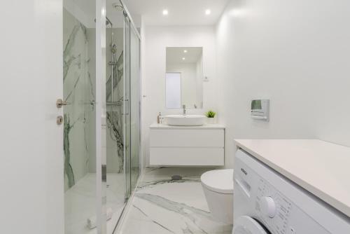 une salle de bain blanche avec douche et toilettes dans l'établissement HostWise Cozy Studio with Balcony and Garage, à Leça da Palmeira