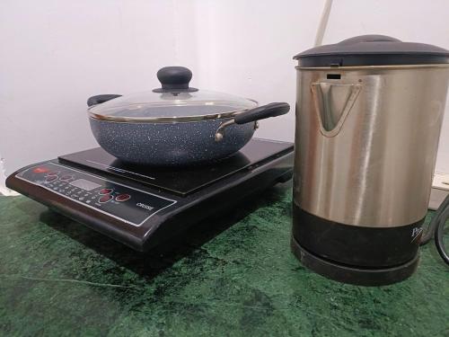 a pot and a pan on top of a stove at Cozy and Tranquil nest with wifi and homely care in Greater Noida