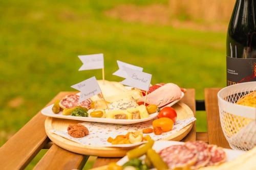 a table with two plates of food and a bottle of wine at Bois aux Cheirilles - 15min Murol - Puy de Dome in Saint-Diéry