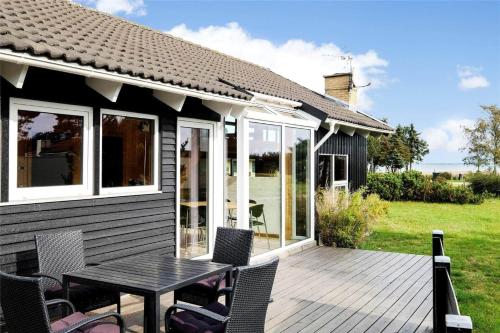 a deck with a table and chairs on a house at OH253-Hadsund-Halvrebene-37 in Hadsund