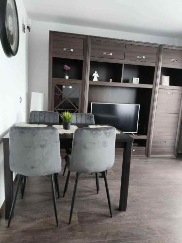 a dining room with a table and four chairs at Alma Apartments Starachowice in Starachowice