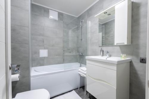 Un baño con lavabo, bañera e inodoro. en Petrovdom Apartments 20-199a in RC Kvartet, Vasylya Lypkivskoho Street 16Г, en Kiev