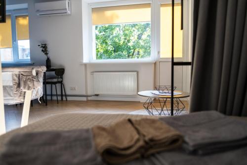 a bedroom with a bed and a window and a table at SongInn Lake Apartment in Zarasai