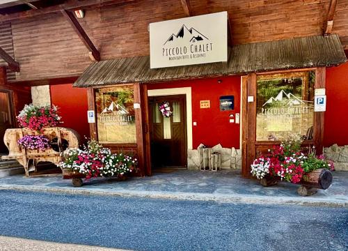 a restaurant with flowers in front of a building at Hotel Piccolo Chalet in Claviere