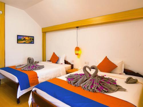 two beds in a hotel room with towels on them at Koh Rong New Beach in Kaôh Rŭng