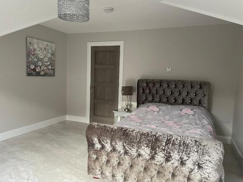 a bedroom with a large bed with a blanket on it at Church Bray View, Dunfanaghy in Dunfanaghy