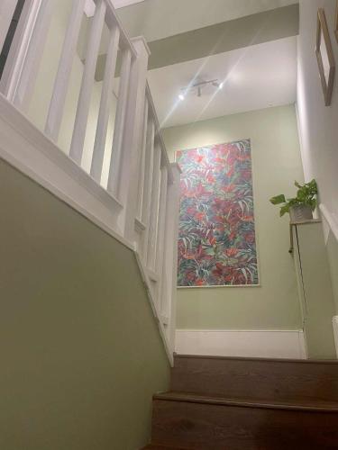 a staircase with a painting on the wall at Bridge House in Broadwater