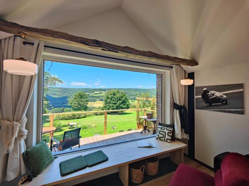 a living room with a large window with a view at Le Clos des Brumes in Stoumont
