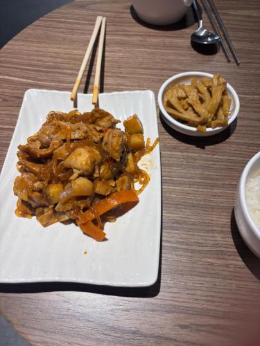 a plate of food with chicken and vegetables on a table at EGSTAY HOTEl in Gwangju