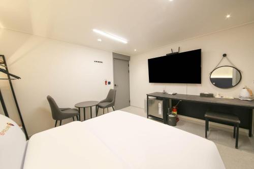 a bedroom with a bed and a desk and a tv at EGSTAY HOTEl in Gwangju