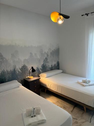 a room with two beds and a lamp on a table at Luxury apartments Alamos beach Torremolinos - Costa Lago in Torremolinos